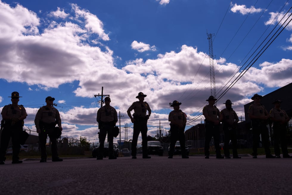ARCHIVO - Agentes de la policía estatal de Illinois hacen guardia mientras un grupo de...