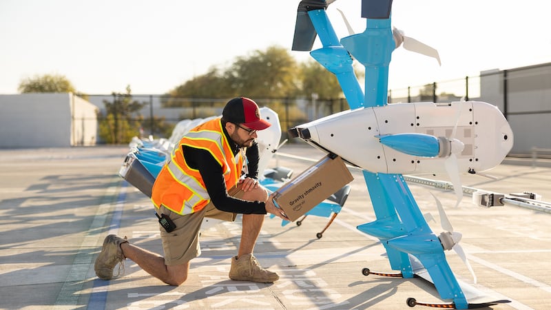 An Amazon employee loads a package into a Prime Air MK30 Drone.