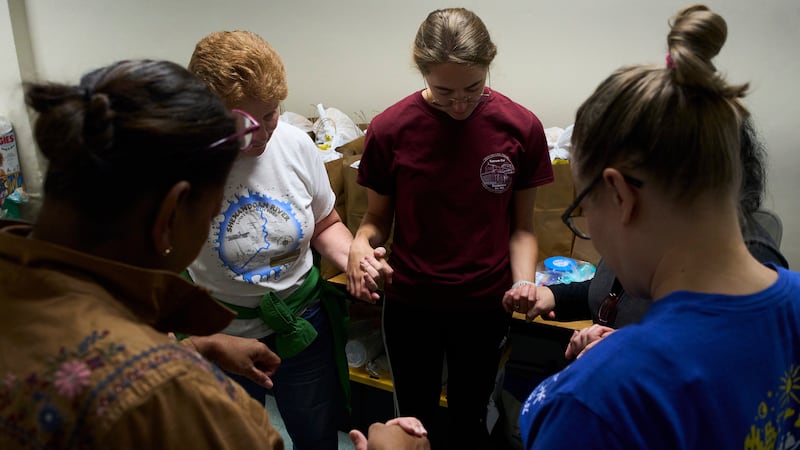 Feligreses del Santuario del Sagrado Corazón y voluntarios rezan en el sótano de una iglesia...