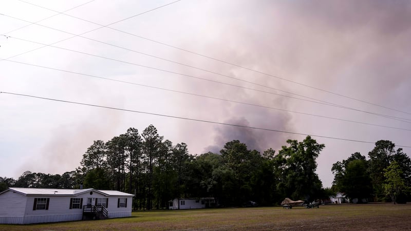 El incendio del camino Pineland, en el condado Brantley, arde detrás de varias viviendas, el...