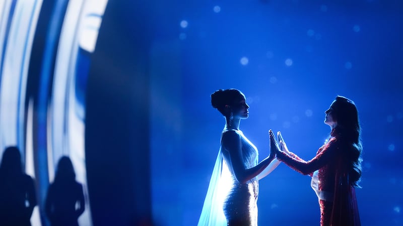 Miss México, Fatima Bosch (derecha), y Miss Tailandia, Praveenar Singh, se toman de la mano...